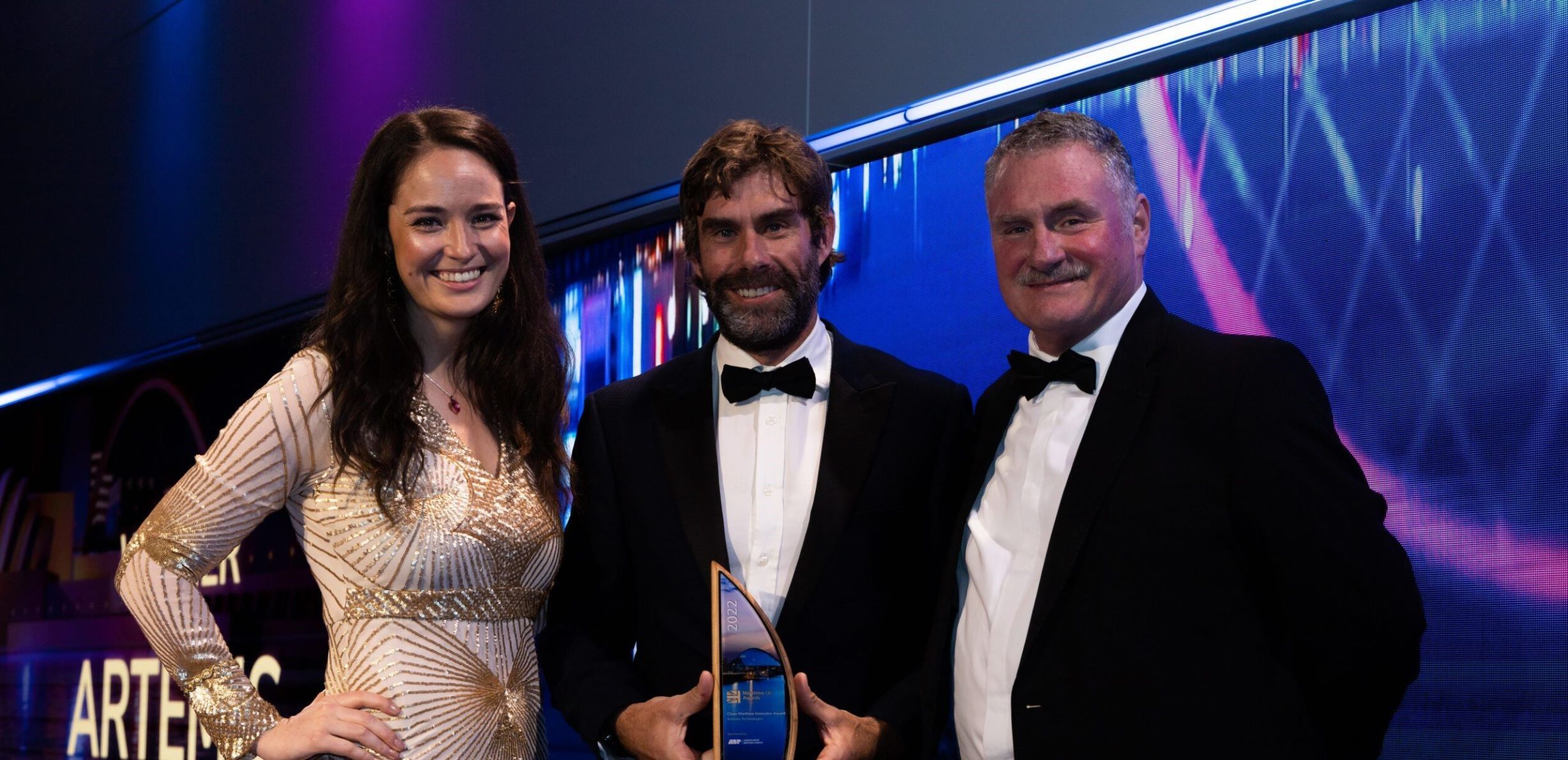 Iain percy holding award onstage with two others