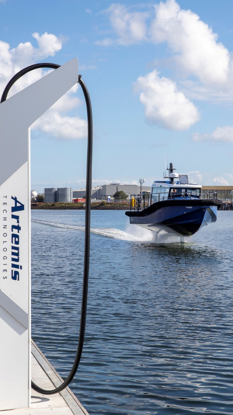 Artemis Technologies EF-12 Workboat foiling past Artemis Technologies charging infastructure