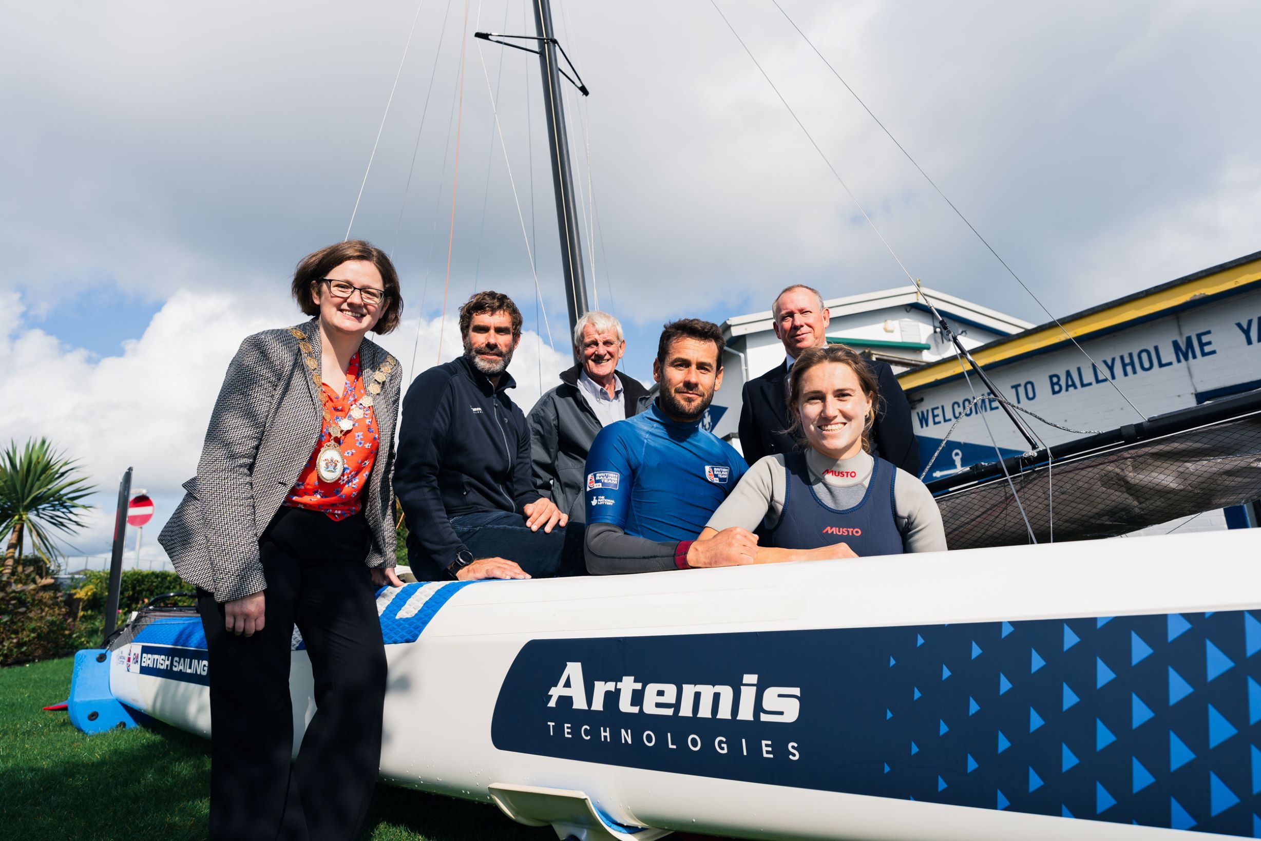 Iain Percy, Anna Burnet and John Gimson with other standing infront of world record breaking racing boat
