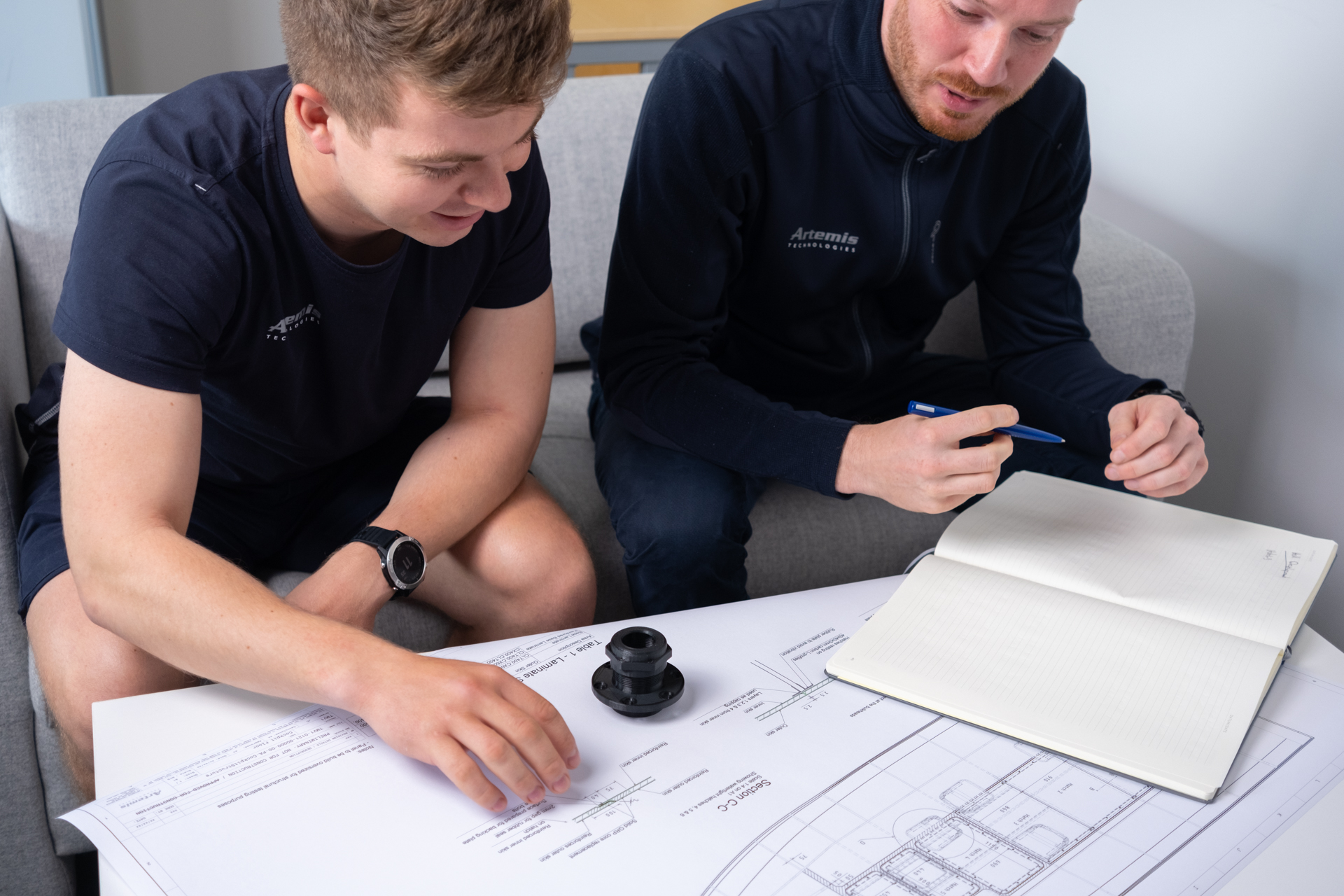 Two men looking at technical drawings