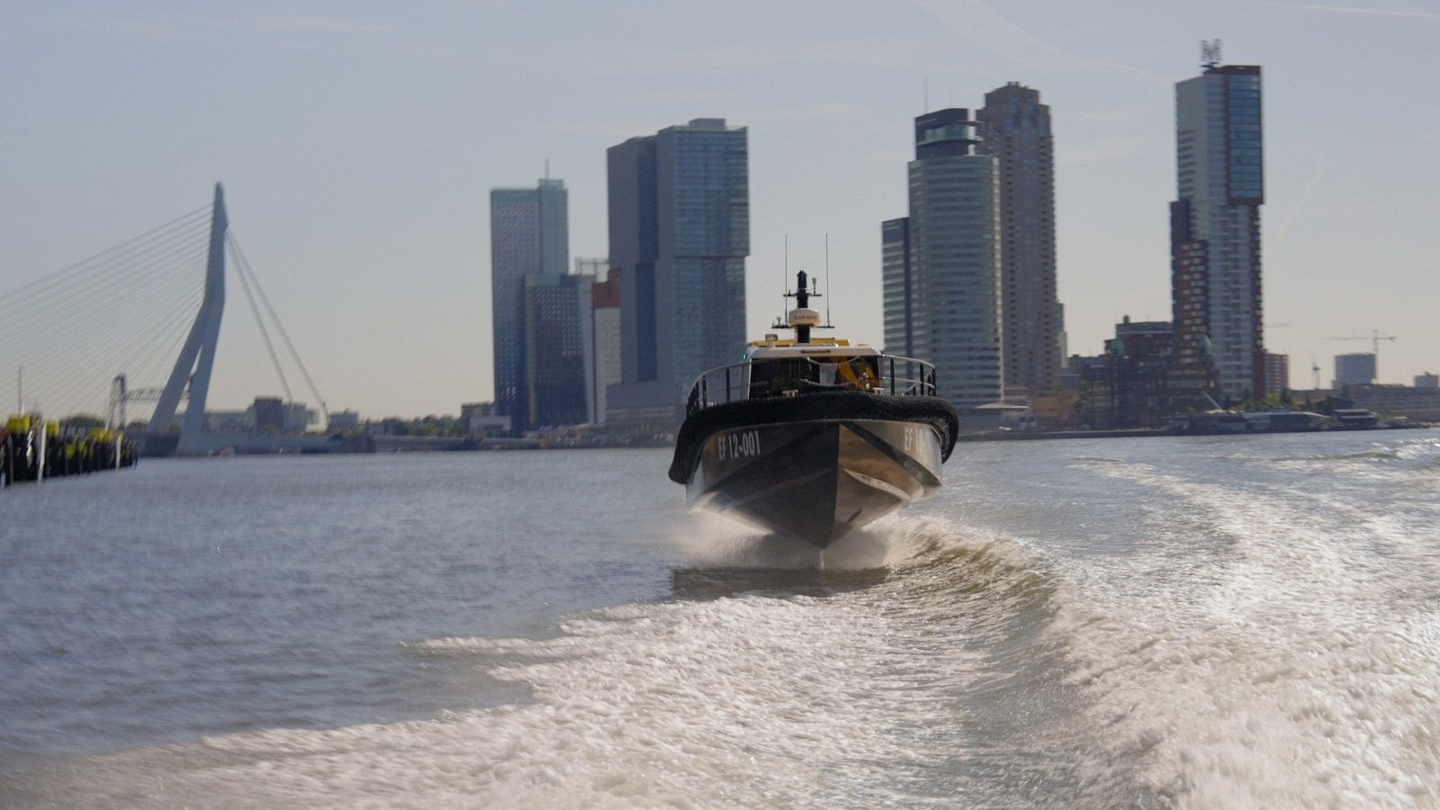 Artemis EF-12 Workboat foiling in Port of Rotterdam with skyline and bridge in the background