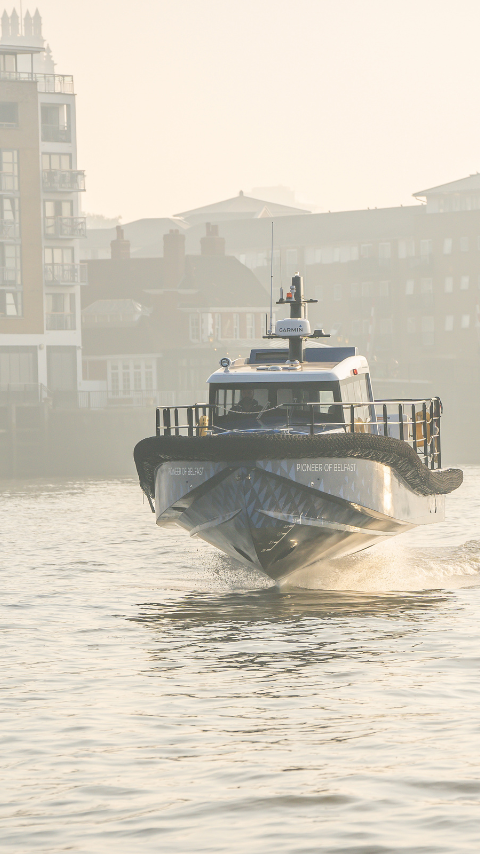 An electric boat foiling with skyscrapers in the background
