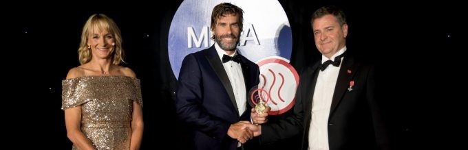Dr Iain Percy accepting the Maritime 2050 award from a lady and a man