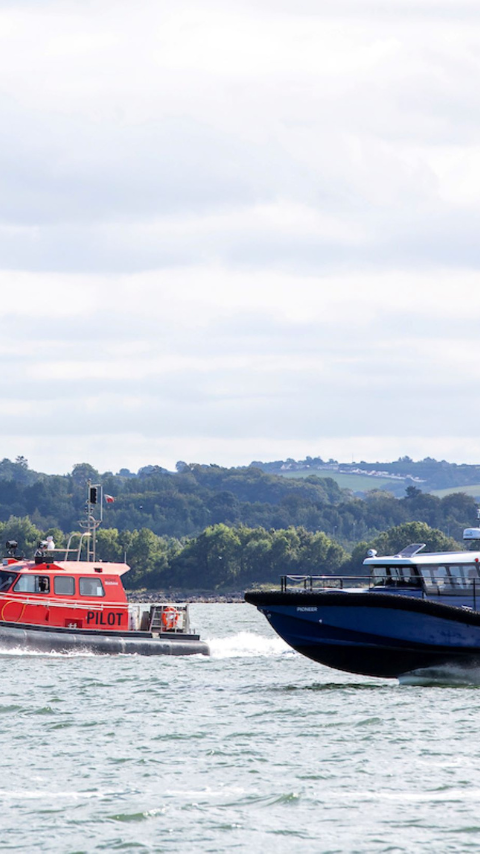 Artemis Technologies EF-12 Workboat foiling alongside pilot boat