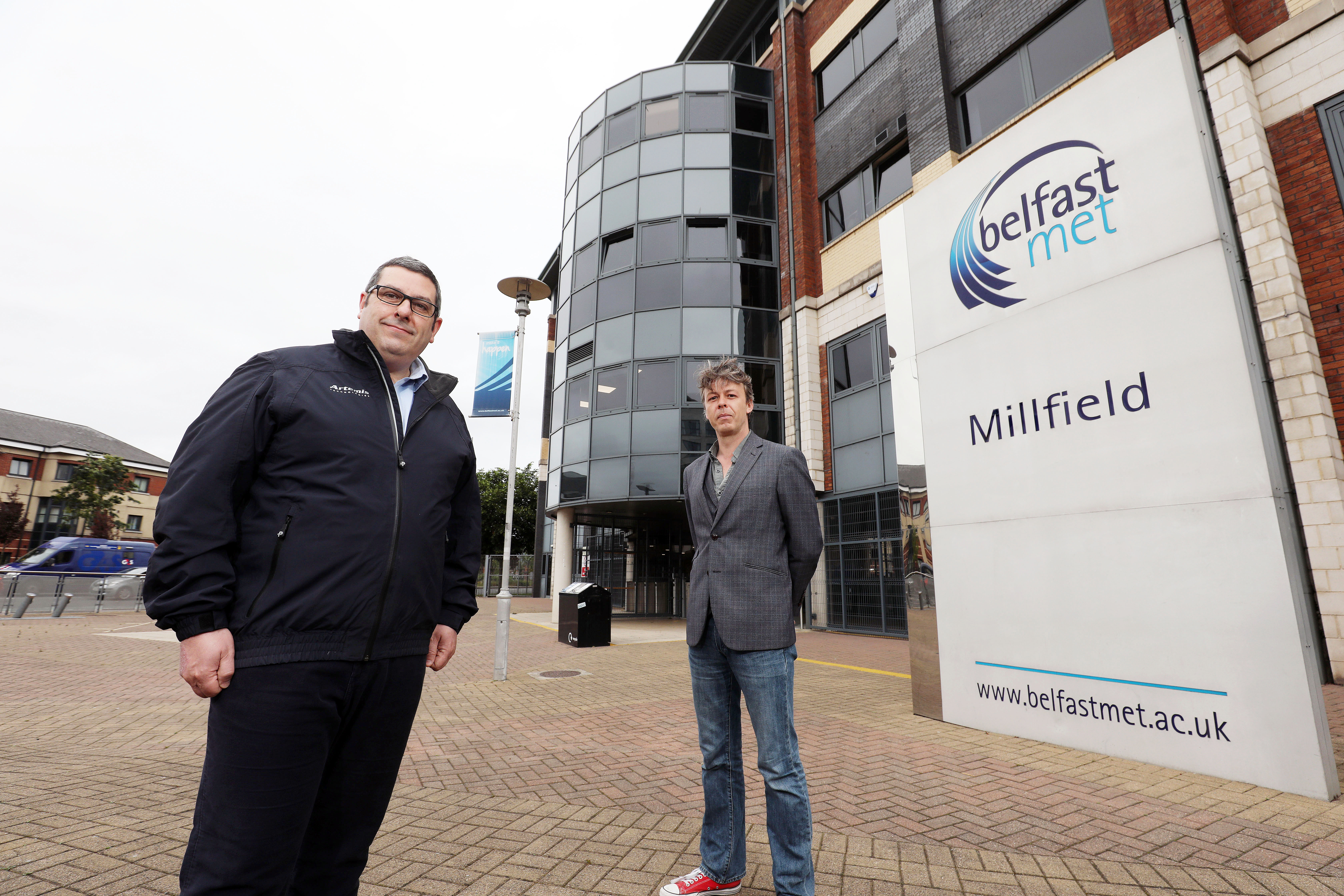 Employee and Belfast Met tutor standing outside Milfield Belfast Met campus