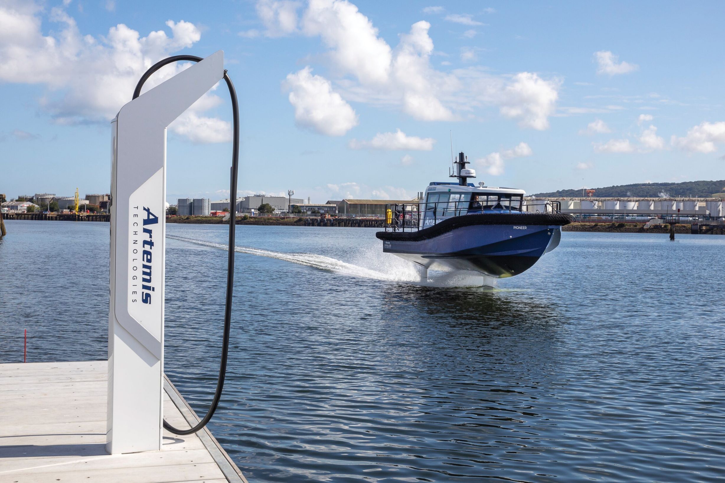 Artemis Technologies EF-12 Workboat foiling past Artemis Technologies charging infastructure