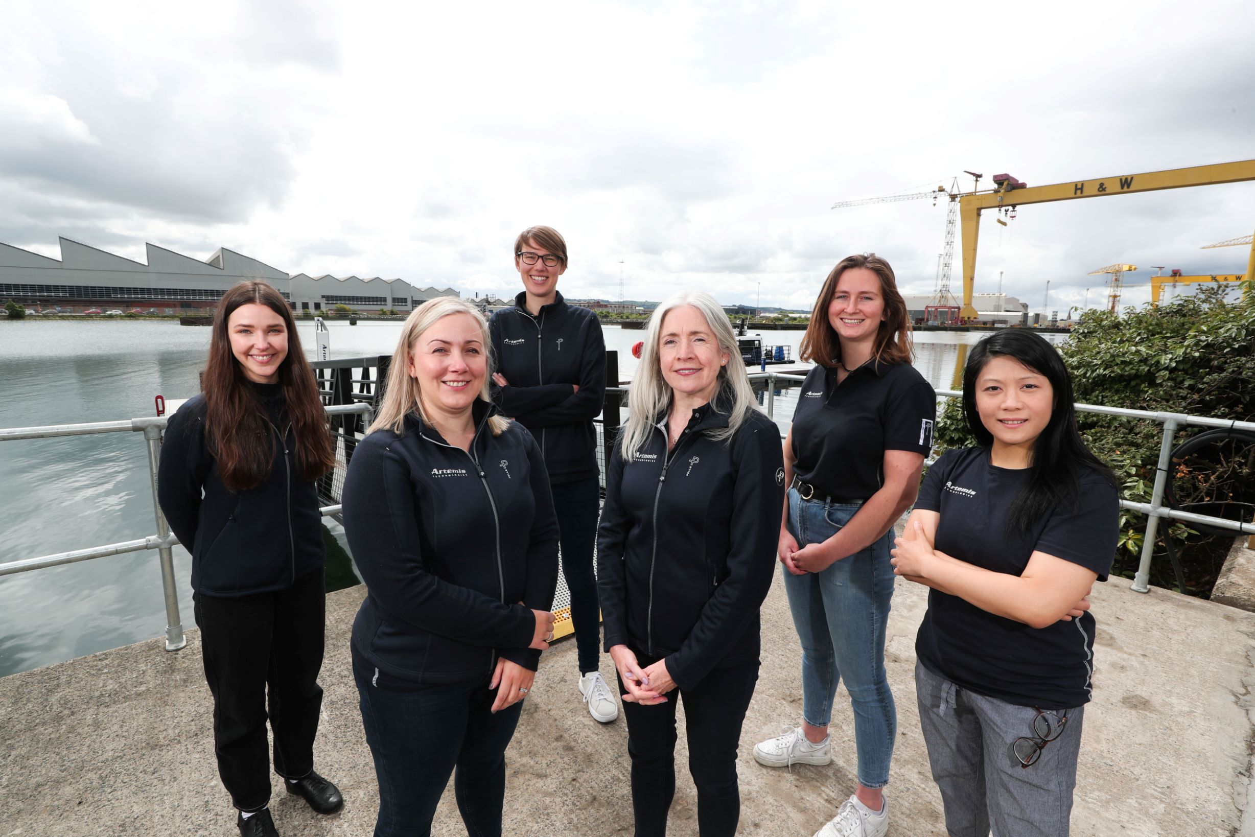 group of six Artemis Technologies women employees standing on pontoon