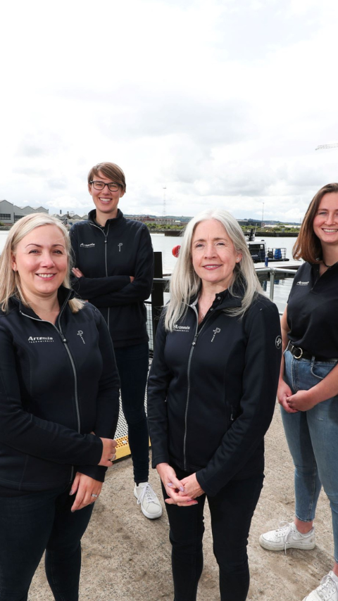 group of six Artemis Technologies women employees standing on pontoon