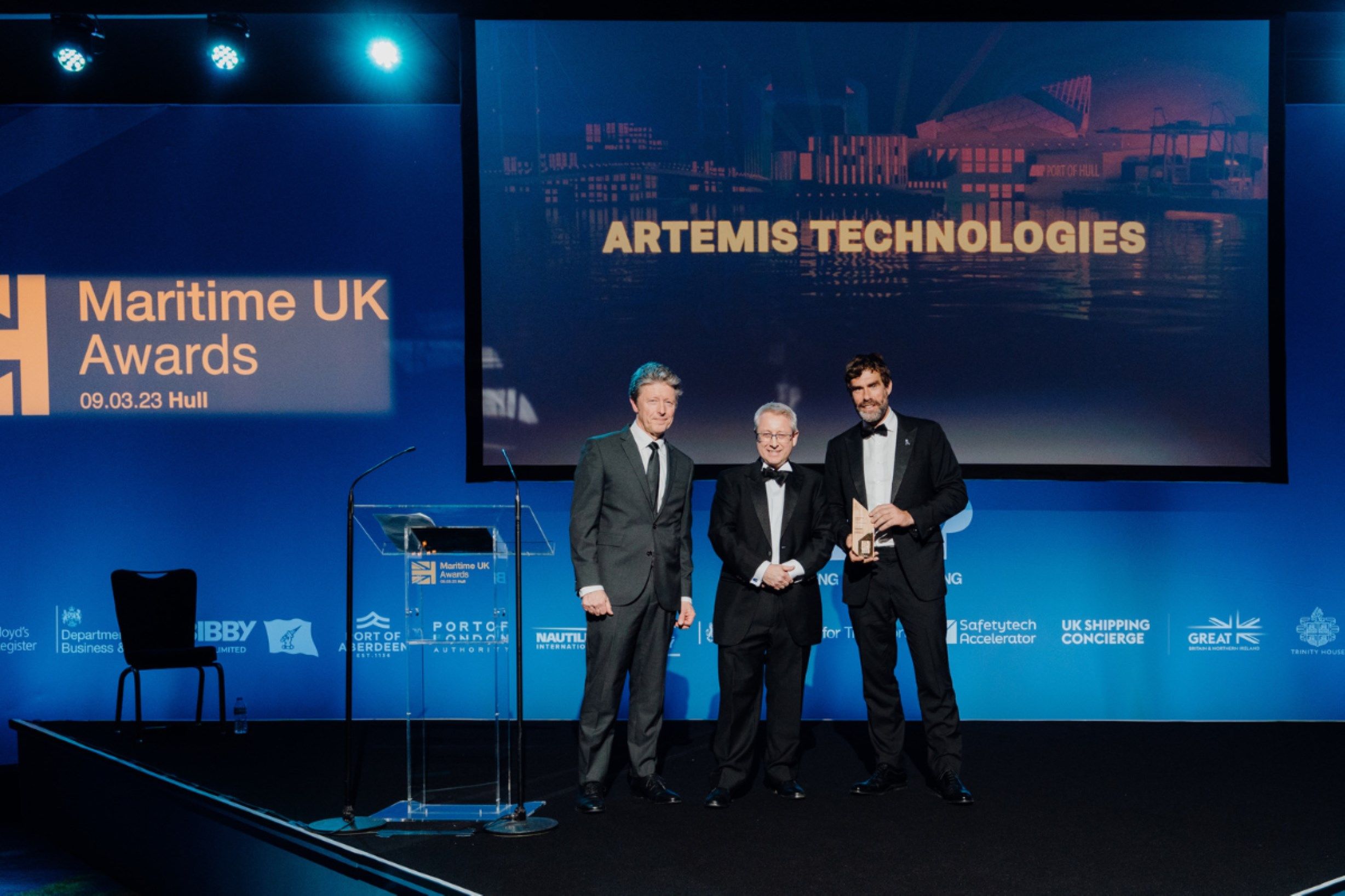 Image of Iain Percy holding award onstage with two others