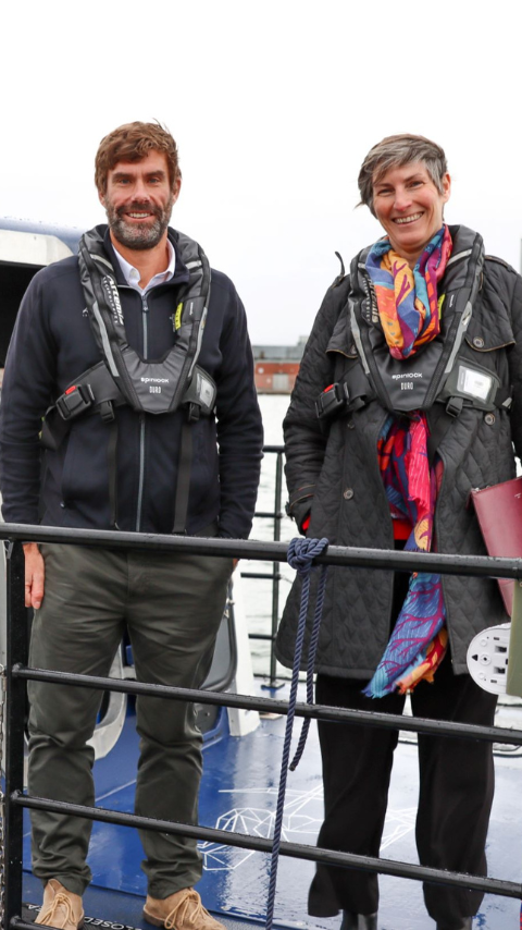 Iain Percy standing with one other on deck of pioneer