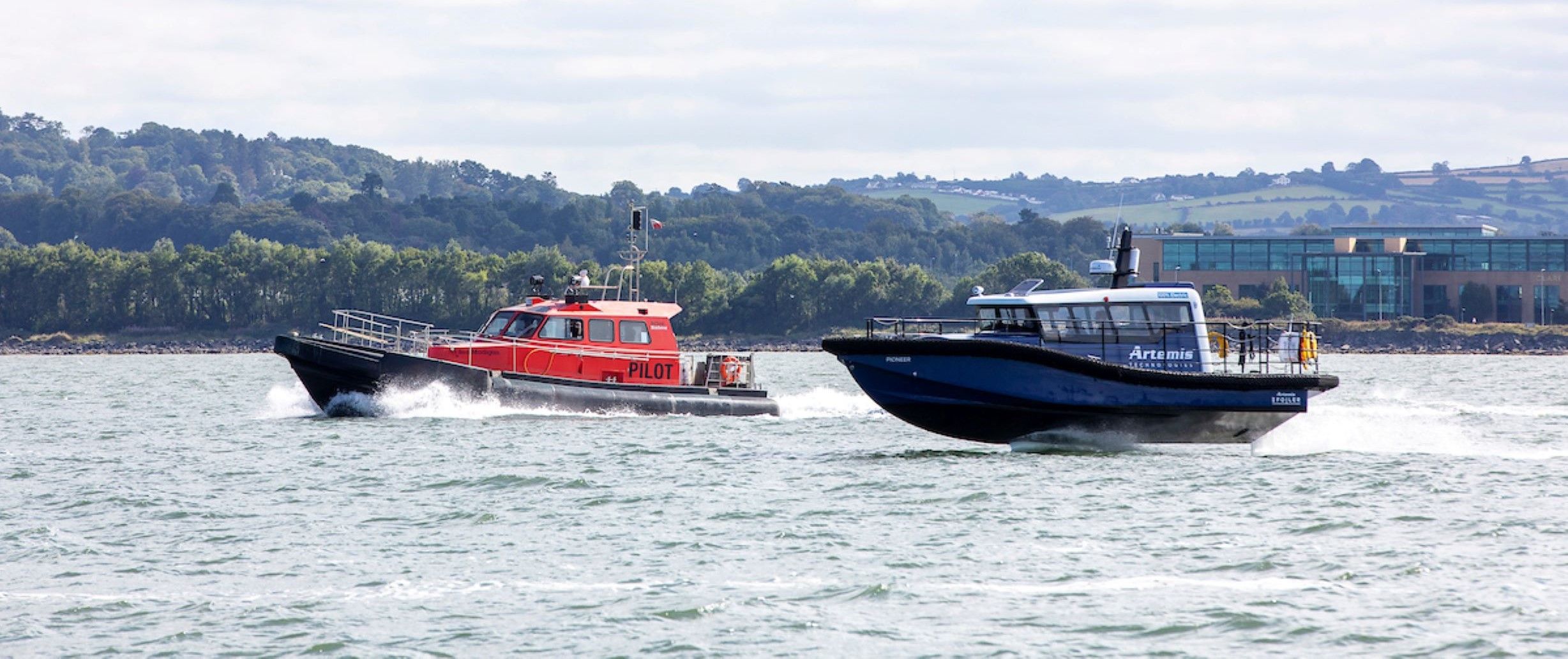 Artemis Technologies EF-12 Workboat foiling alongside pilot boat
