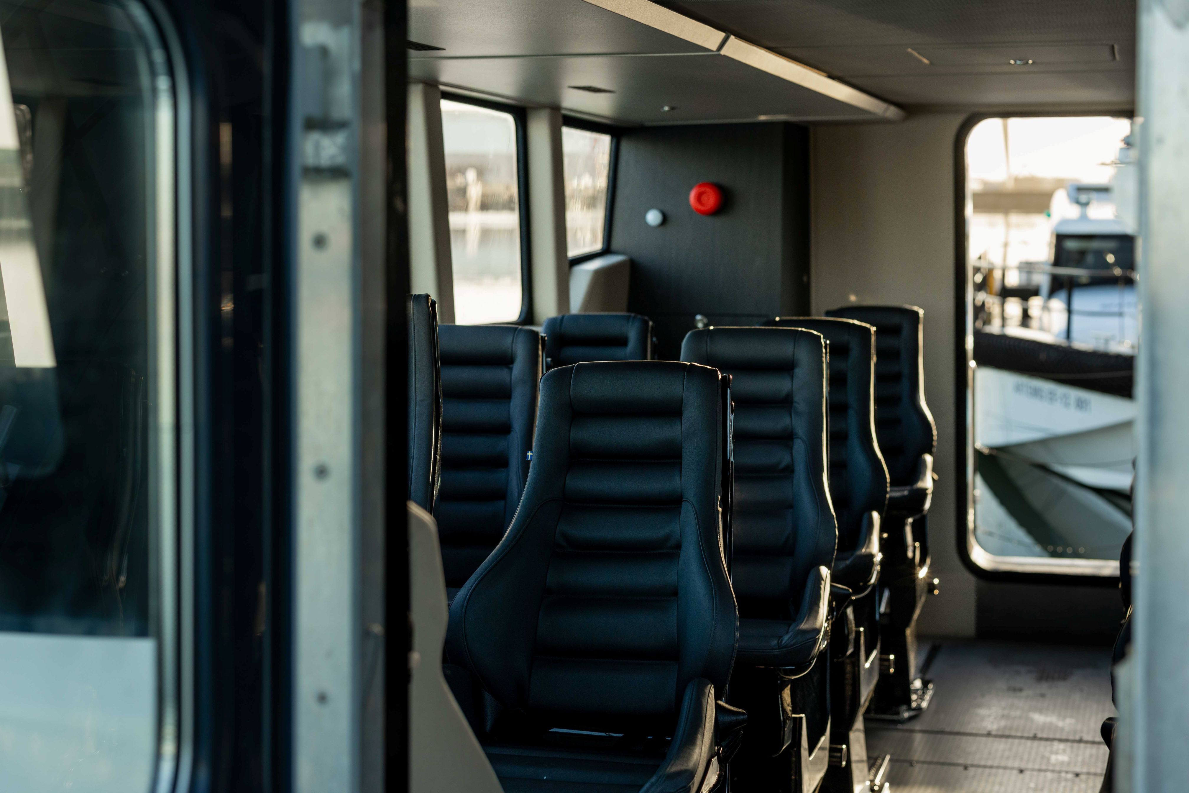 Looking through the front open door to one side of the black seats inside the Artemis EF-12 Workboat XL