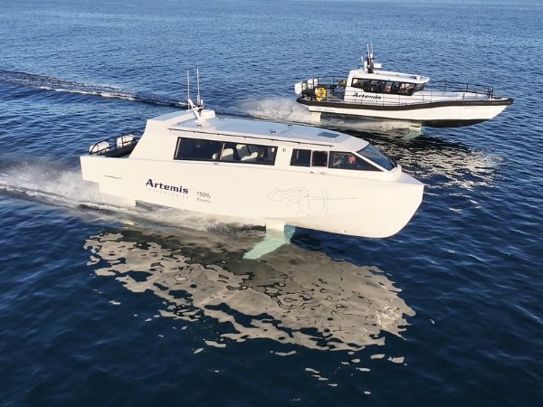 Artemis EF-12 Escape and Artemis EF-12 Workboat foiling of the coast of Barcelona on a sunny day