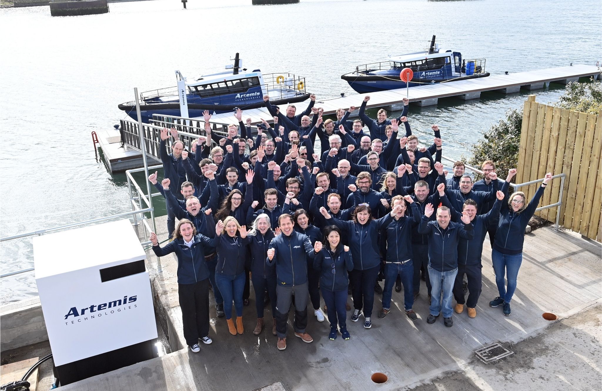 Artemis Technologies employees celebrating at the top of the pontoon