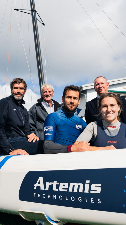 Iain Percy, Anna Burnet and John Gimson with other standing infront of world record breaking racing boat