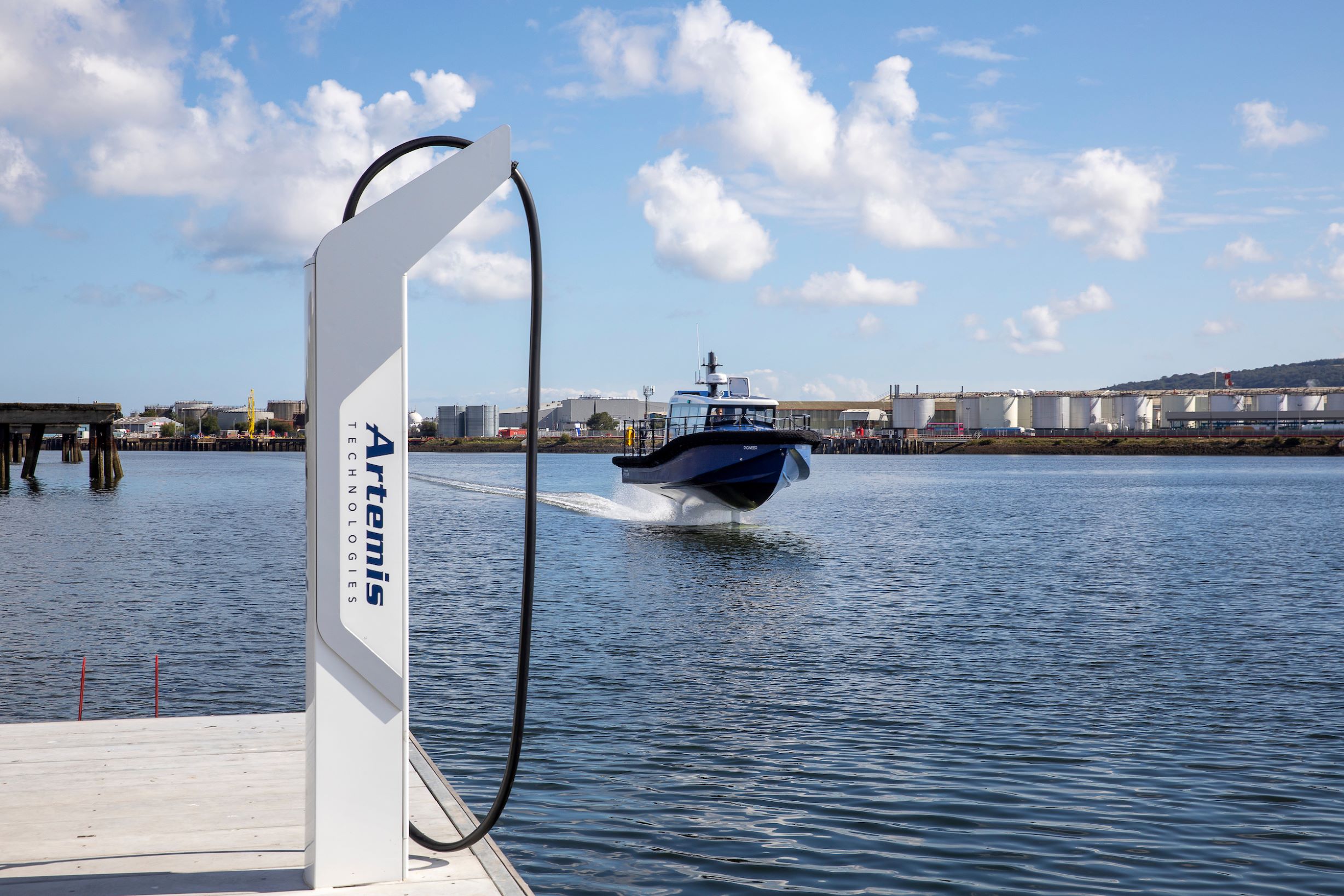 Artemis Technologies EF-12 Workboat foiling past Artemis Technologies charging infastructure