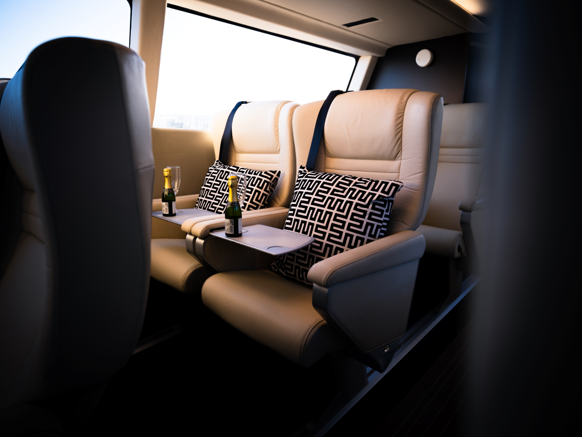 Seats inside a boat with cushions and champagne