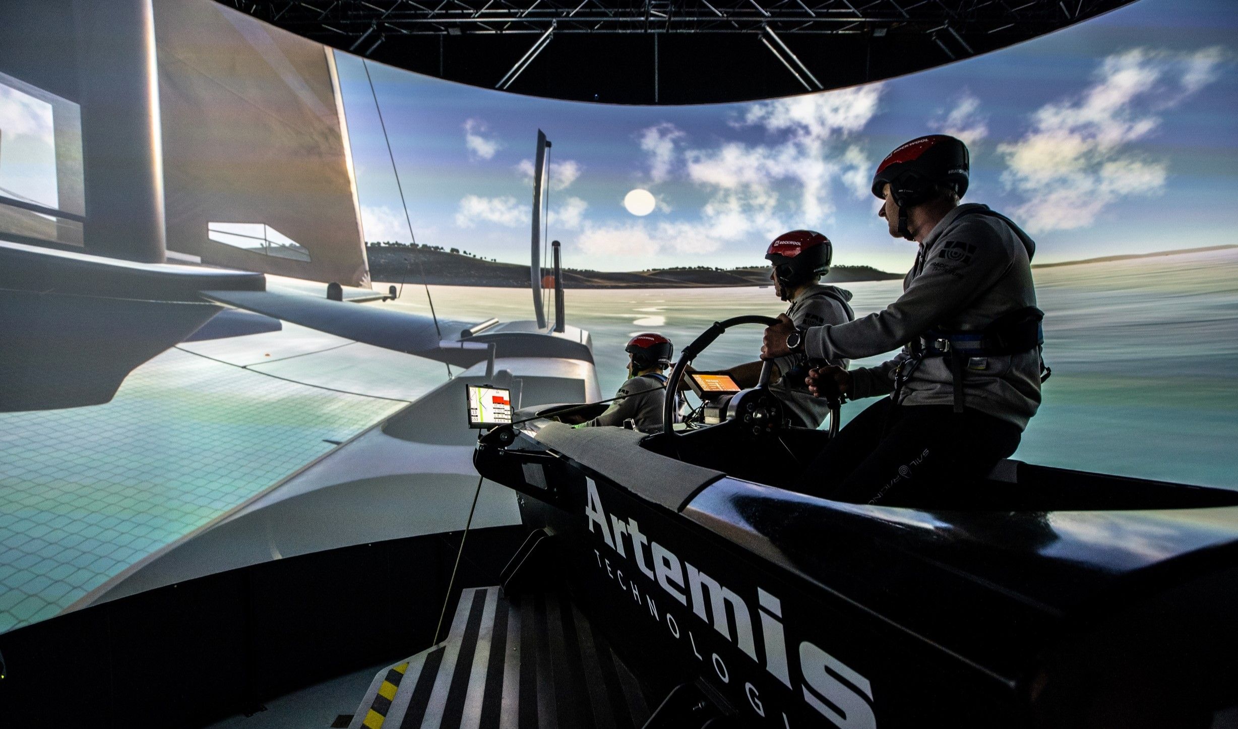 Three men from the Denmark SailGP team in a sailing simulator at Artemis Technologies in Northern Ireland