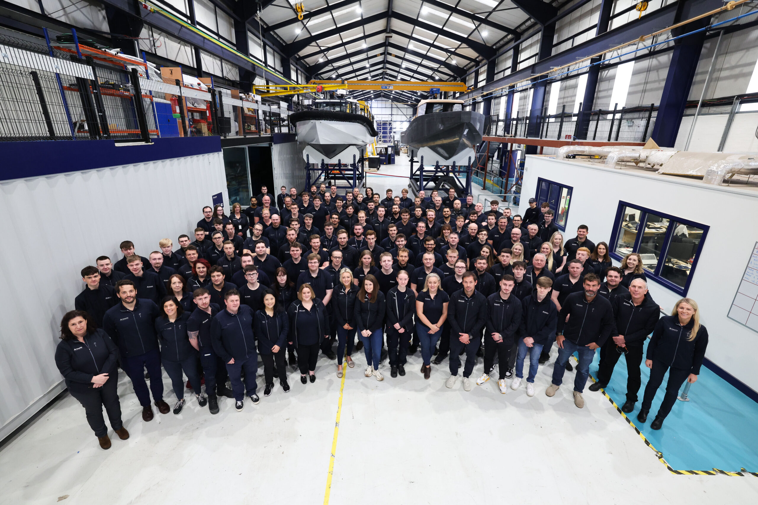 Group shot of 150 employees in manufacturing facility