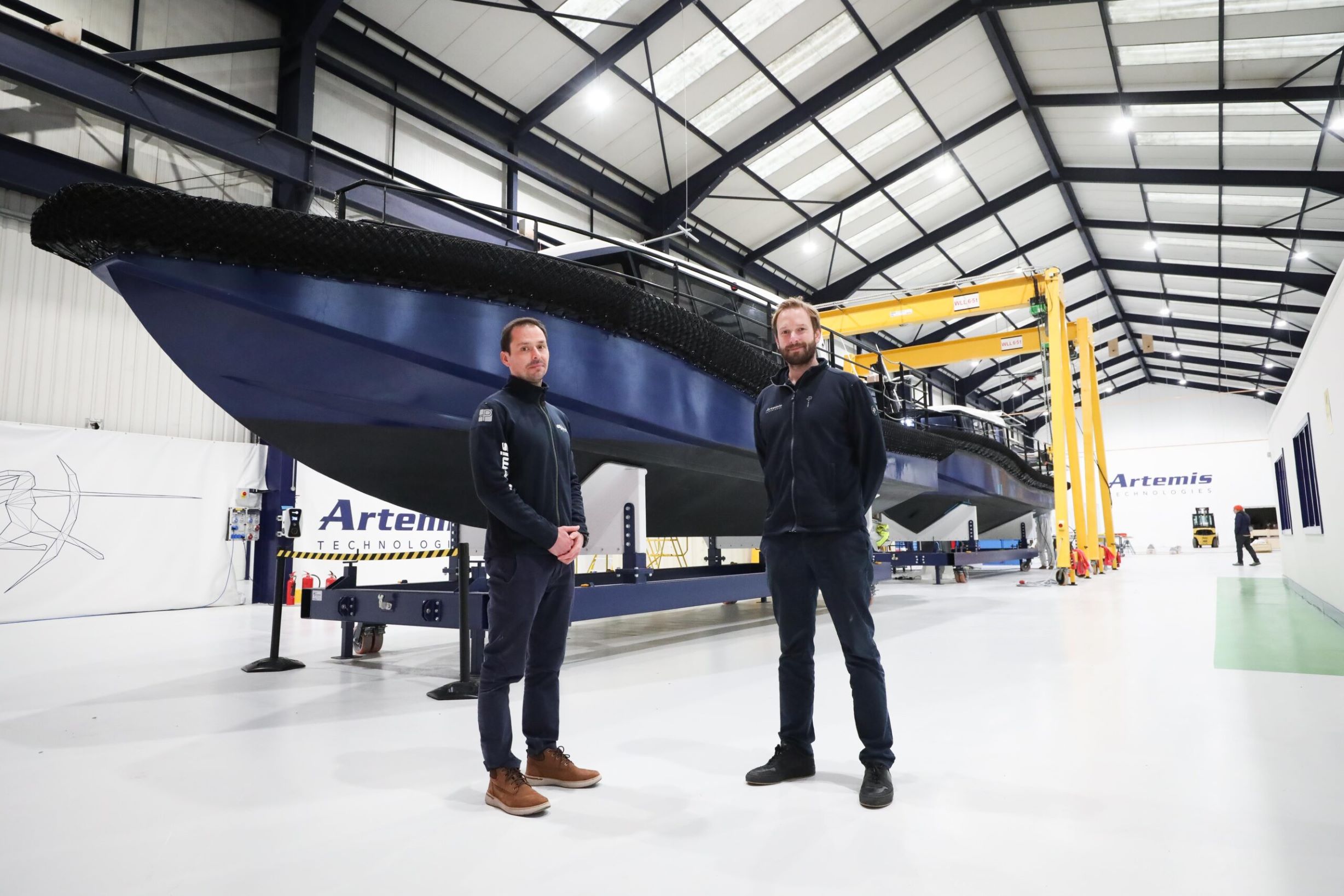 David Tyler and Romain Ingouf standing infront of Artemis Technologies EF-12 Workboat in new facility