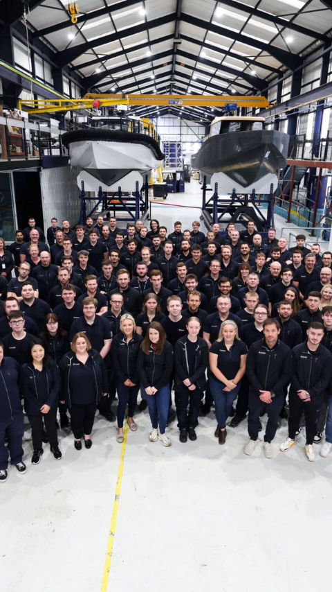 Group shot of 150 employees in manufacturing facility