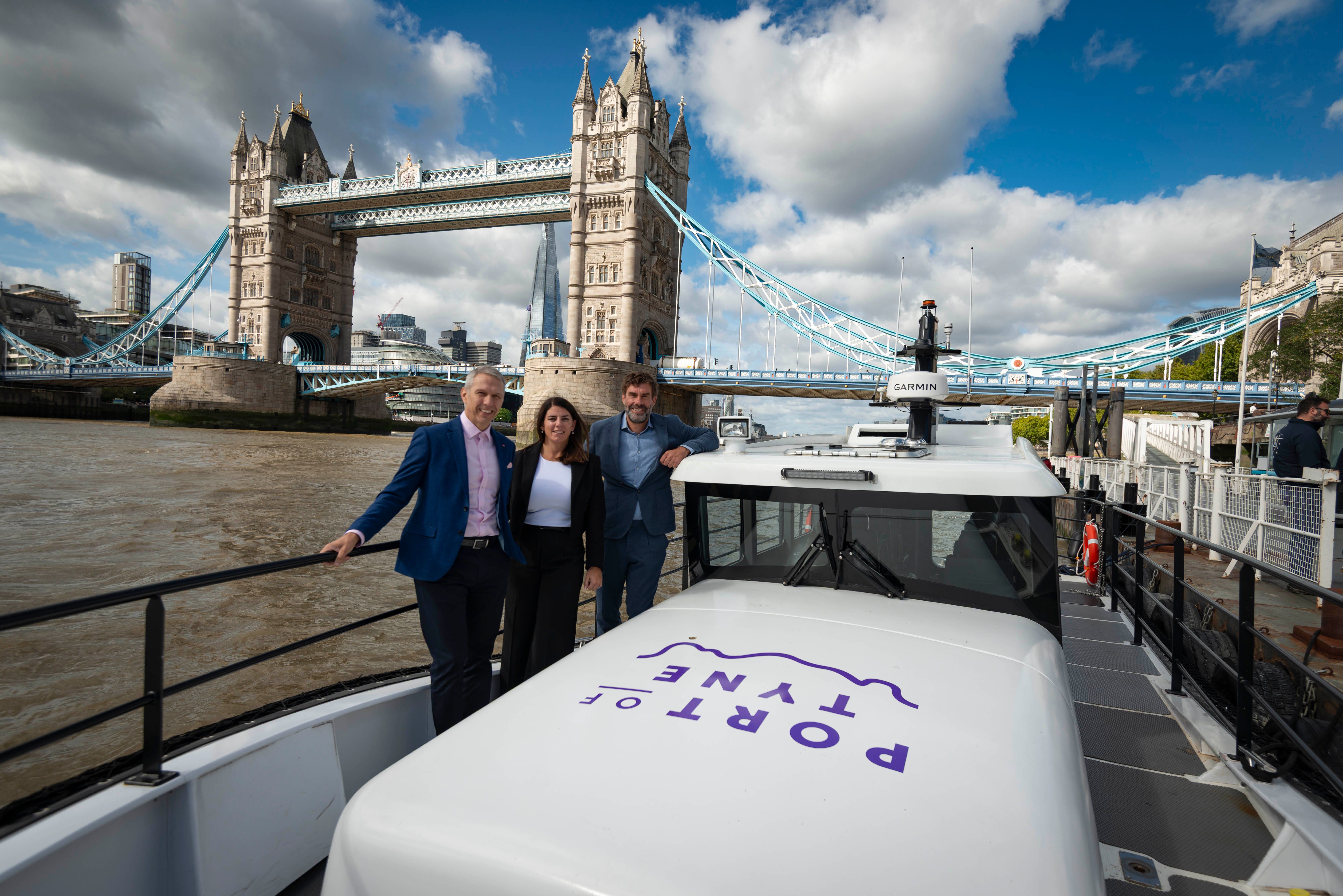 Matt Beeton, CEO of Port of Tyne, Ashley Nicholson MBE, Chief Business Officer, Port of Tyne and Dr Iain Percy, CEO Artemis Technologies on a white 100% electric Artemis EF-12 Workboat with the London Tower Bridge and the Shard in the backdrop.