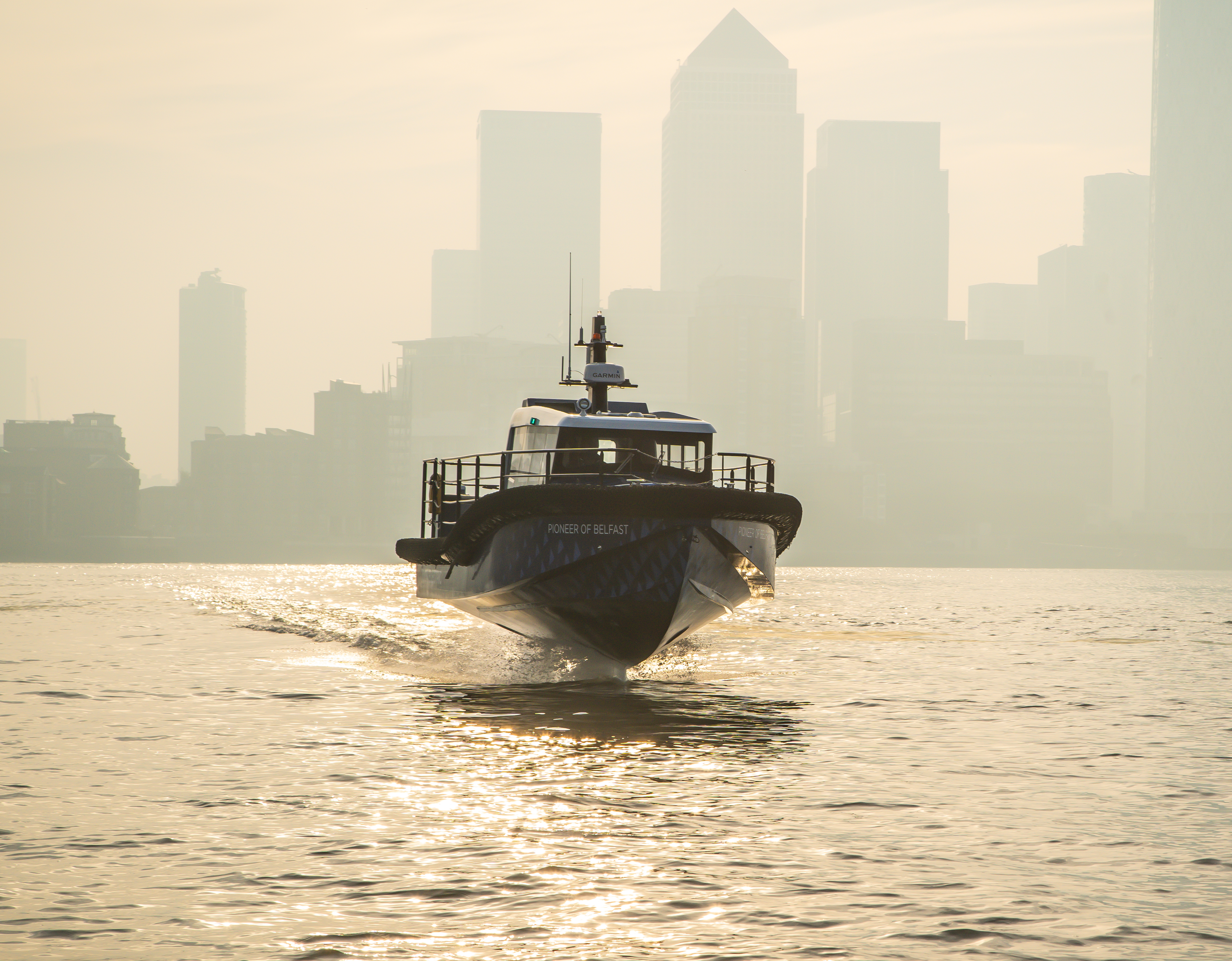 A workboat foiling against a backdrop of skyscrapers