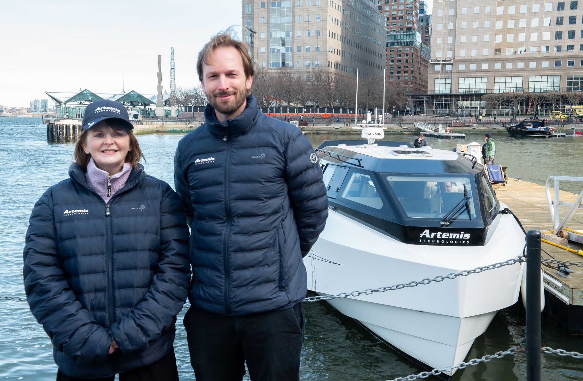 A woman and man standing in front of a boat